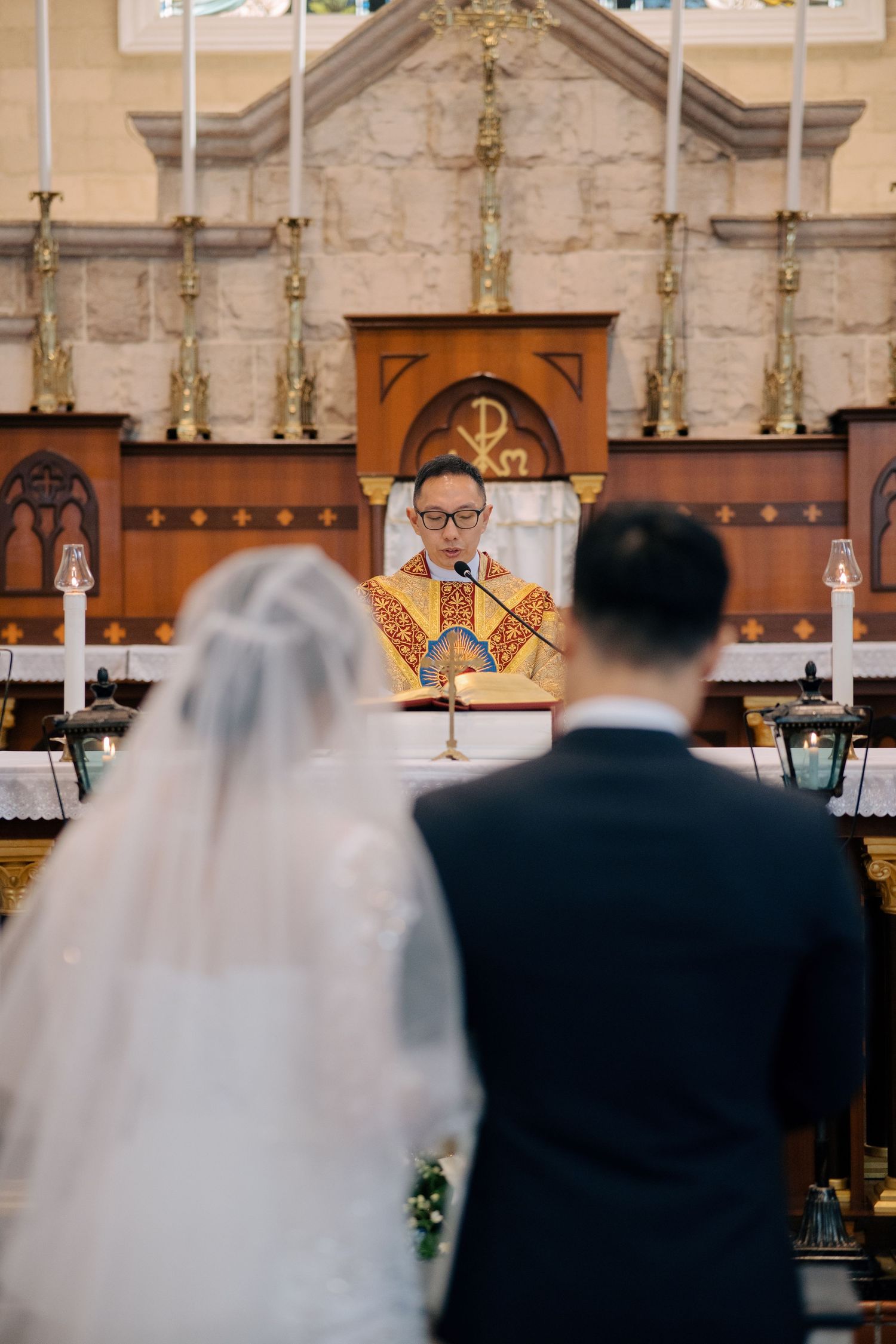The officiating priest speaking to the couple at the altar during a traditional church wedding ceremony