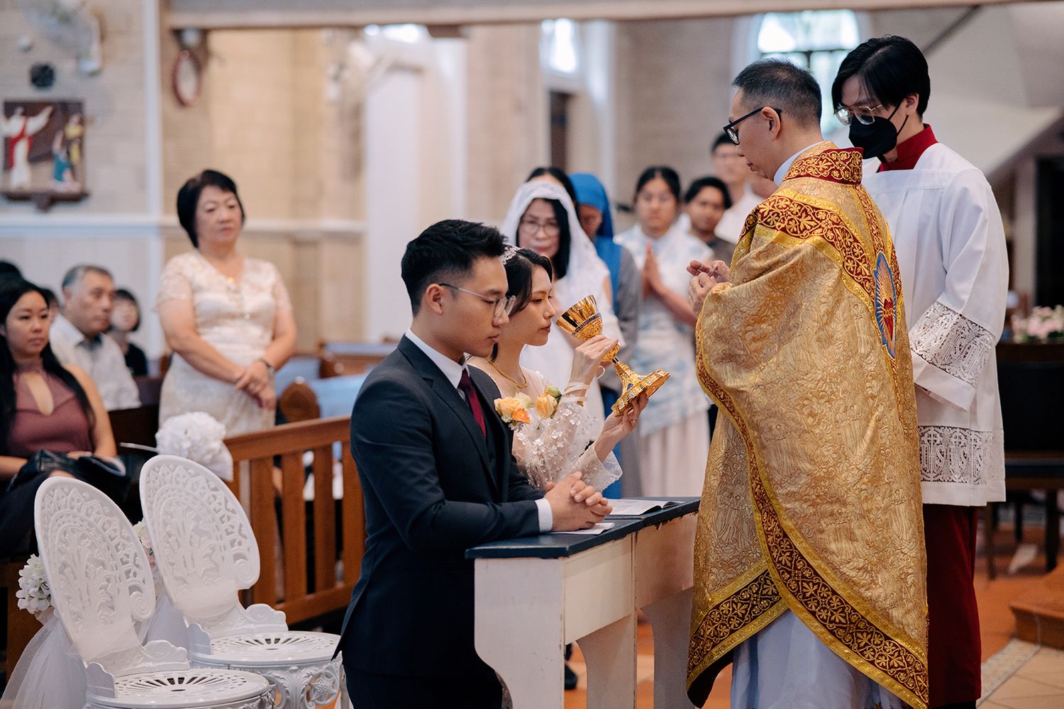 Bride receiving Holy Communion under the appearance of wine at a Catholic wedding