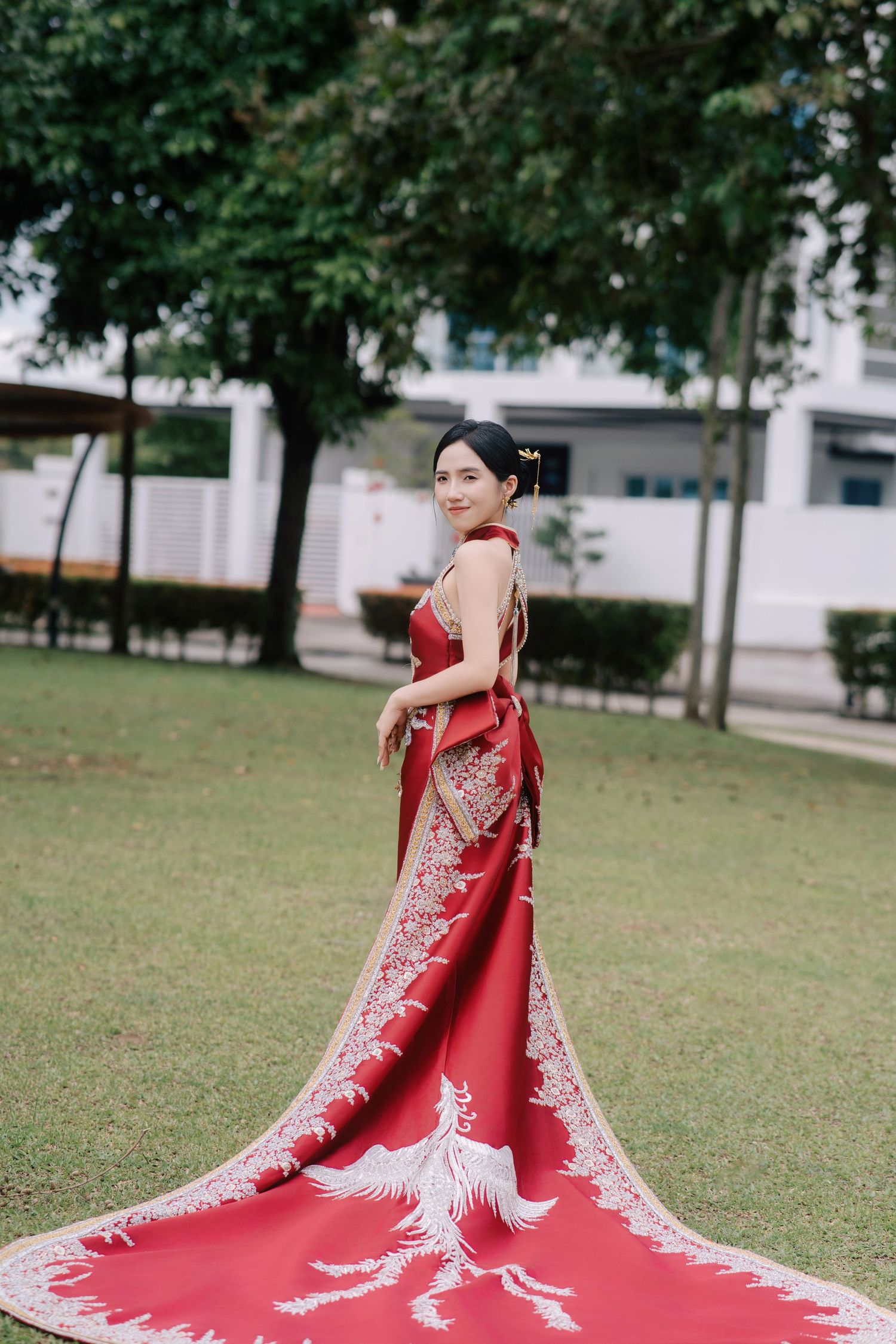 Bride in a red embroidered qipao and gold hair ornaments posing for her traditional Chinese wedding portraits