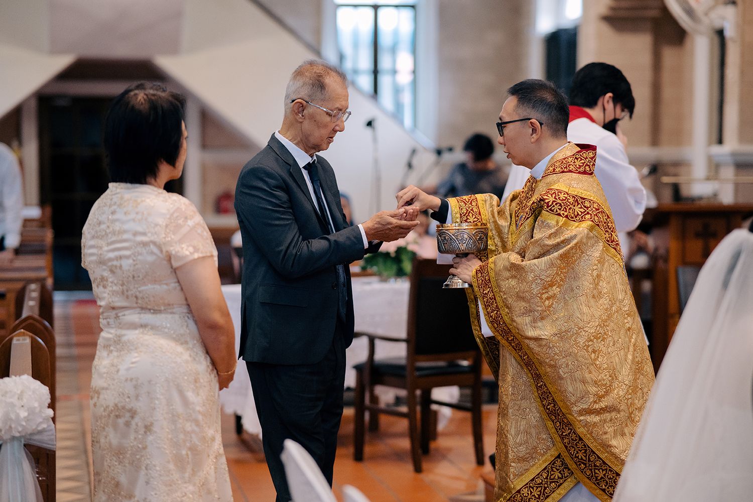 Wedding guests receiving Holy Communion from the priest during a Catholic mass