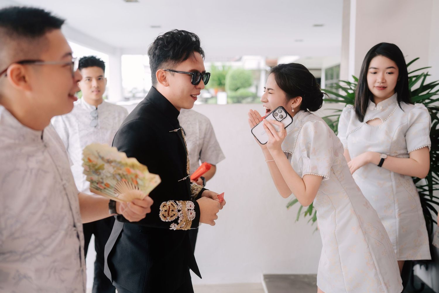 Fun interaction between bridesmaid and groom during traditional Chinese wedding gate-crashing games