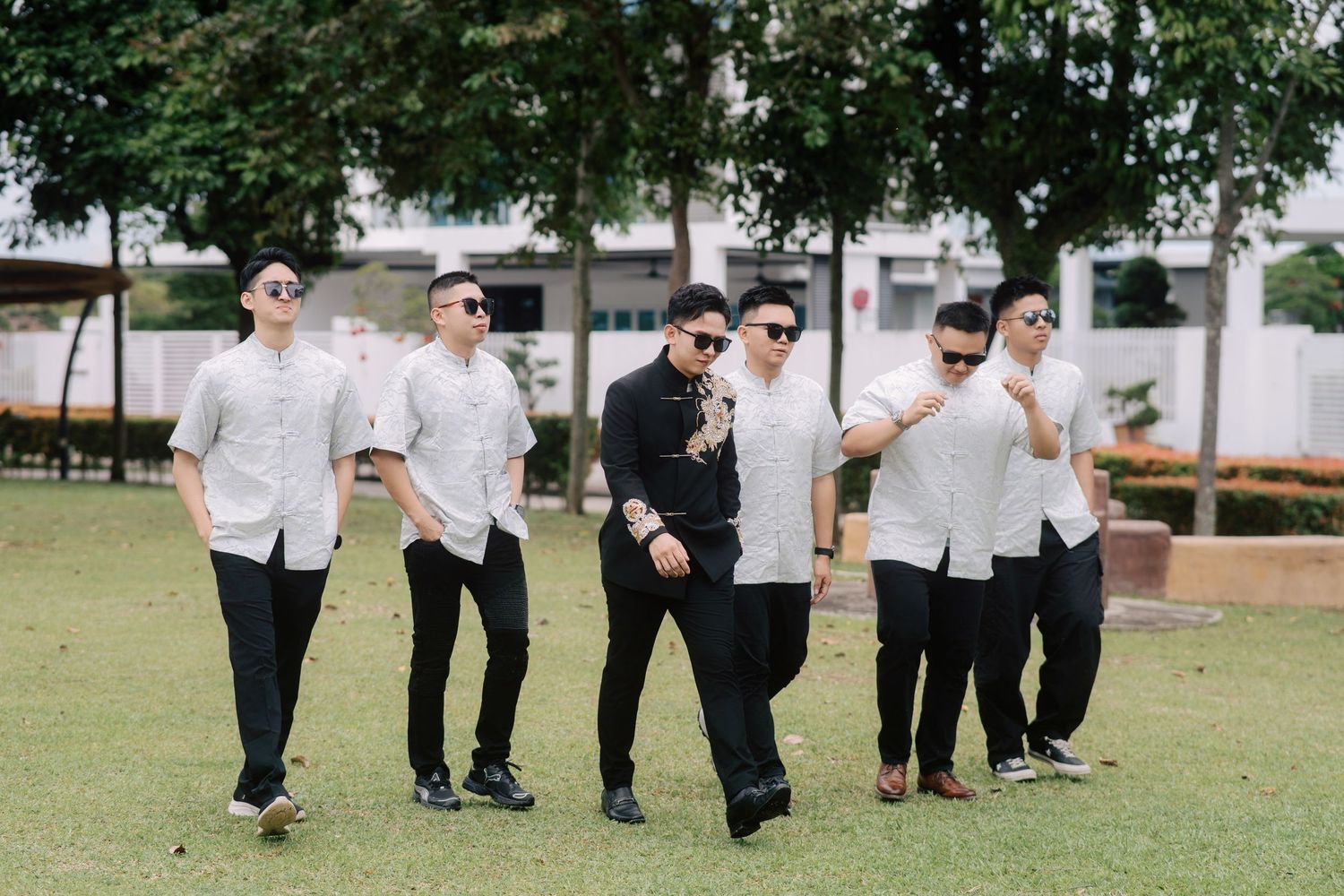 Stylish walk by the groom and his groomsmen during an outdoor Penang Chinese wedding photo shoot