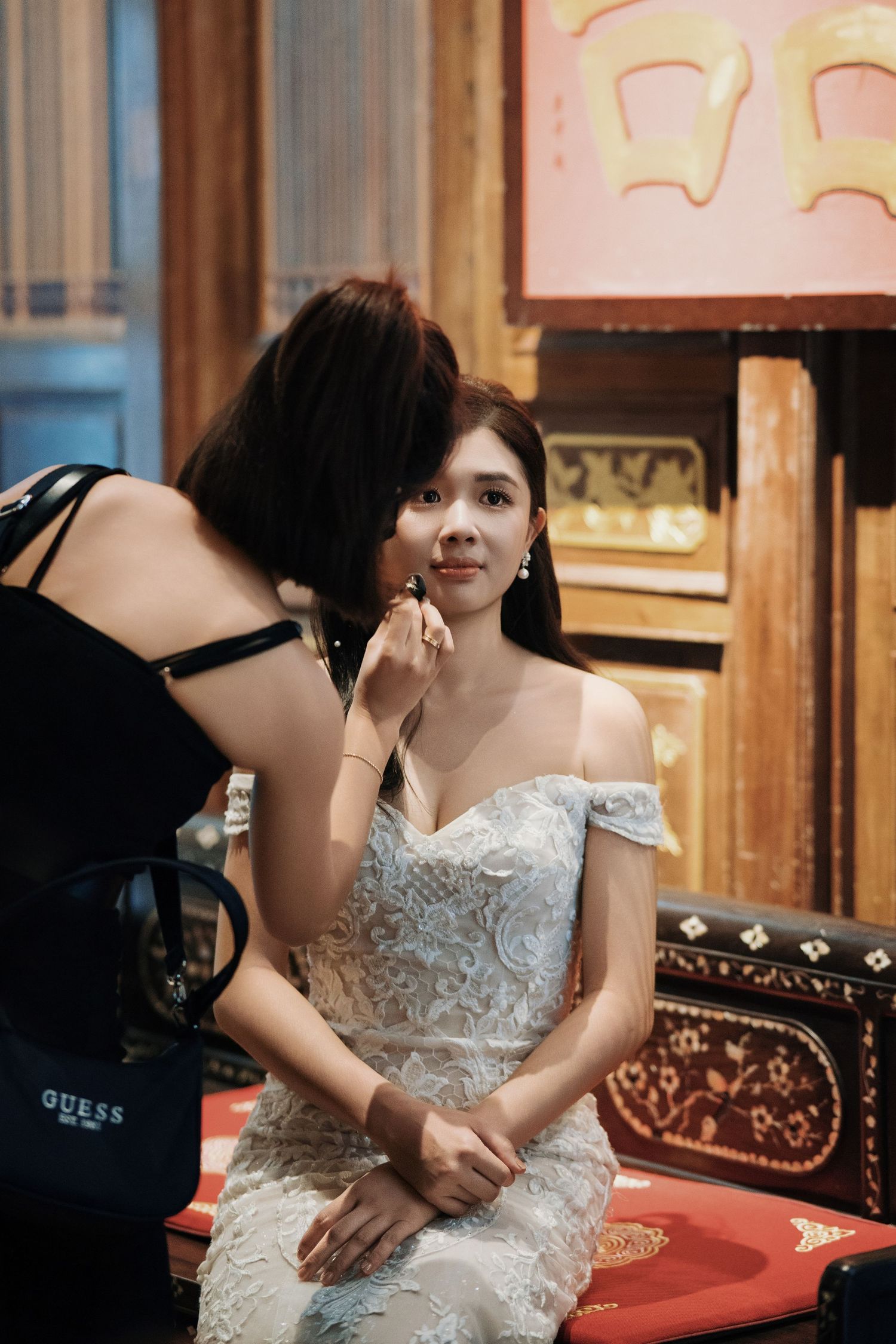 Makeup artist touching up the bride’s face before her Seven Terraces wedding tea ceremony
