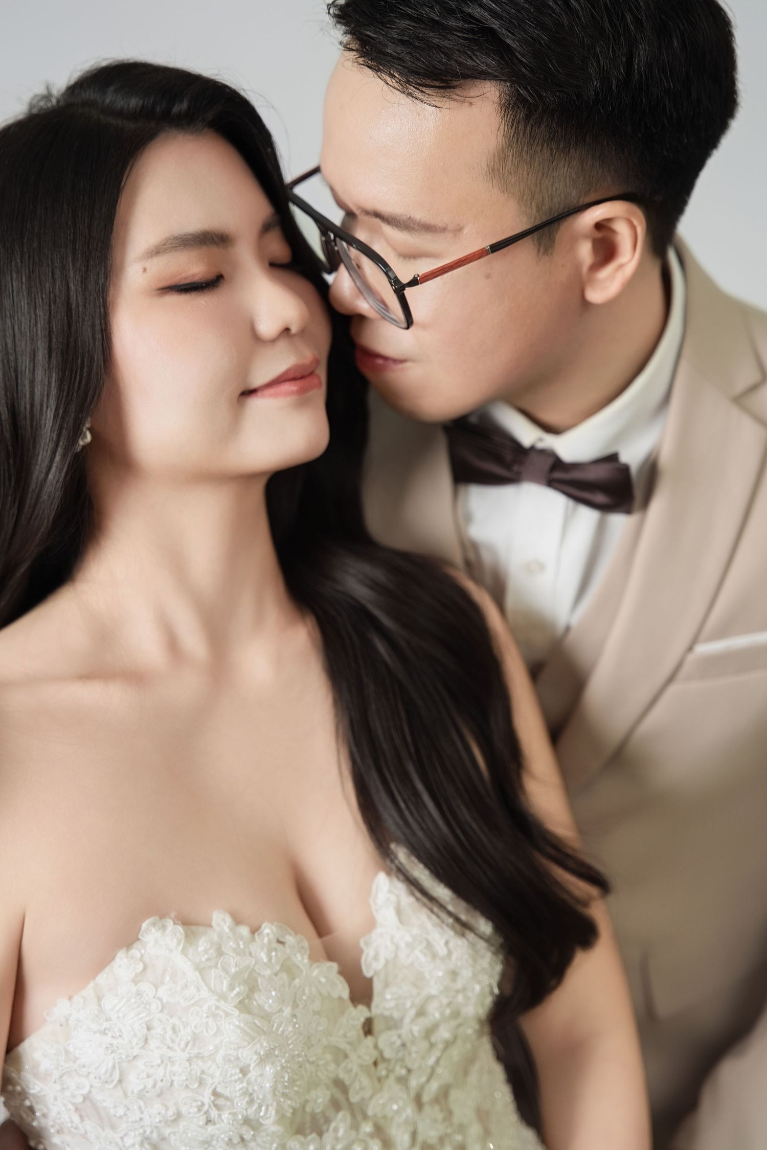 Intimate wedding portraits captured against a minimalist studio backdrop.