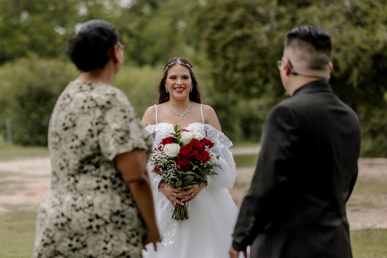 Outdoor wedding ceremony setup with guests and decorations in a natural setting.