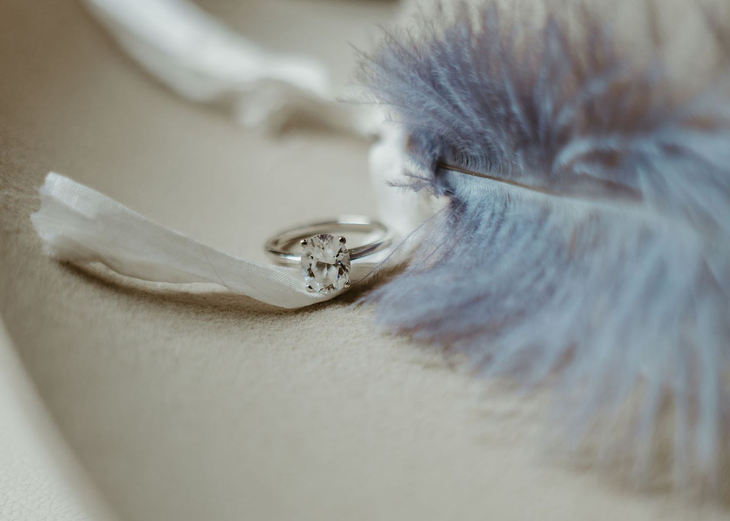 Wedding details of the ring and a cowboy hat and dusty blue feather.