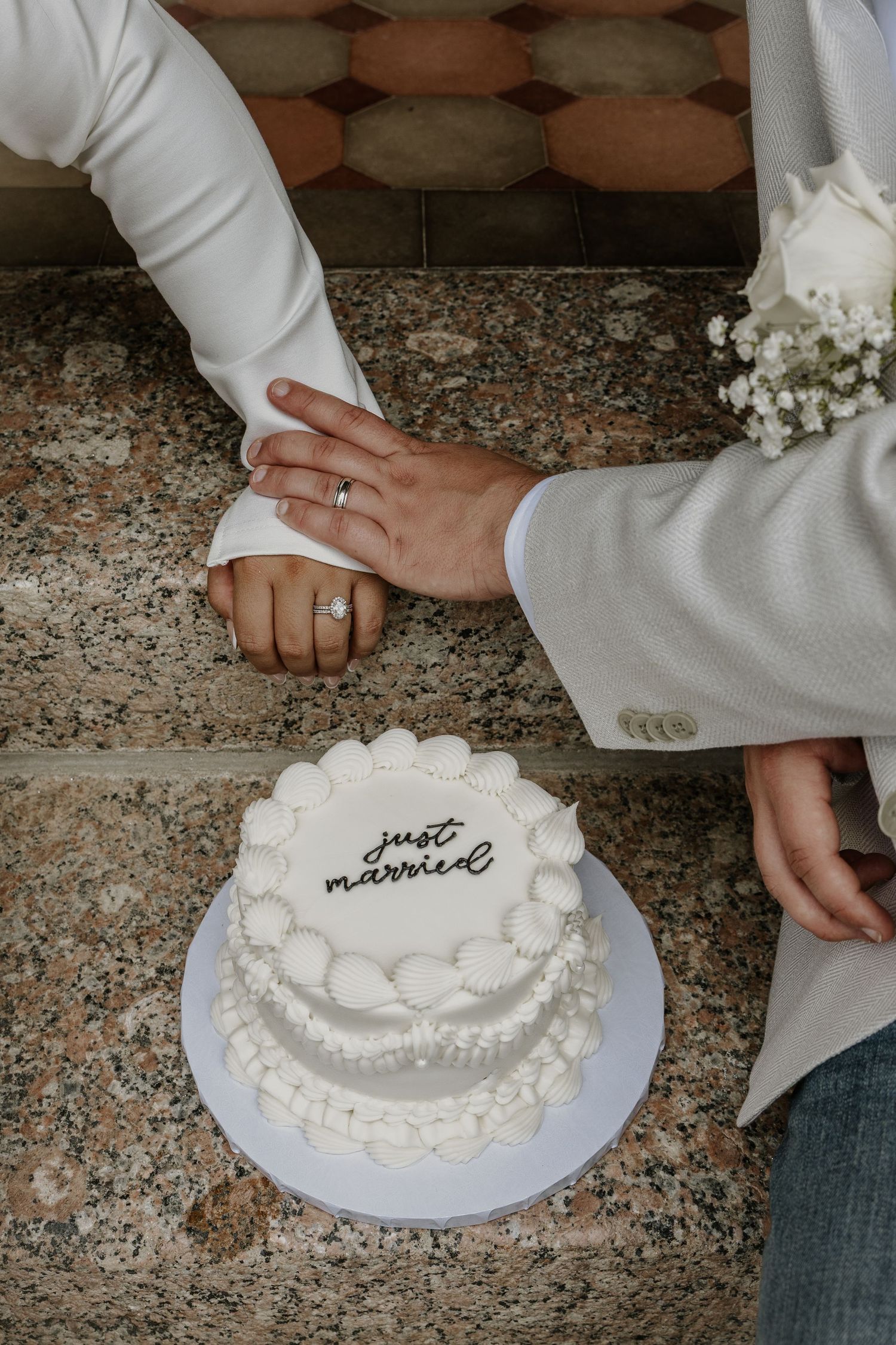 Close-up shots of hands cutting a white wedding cake decorated with pearls.