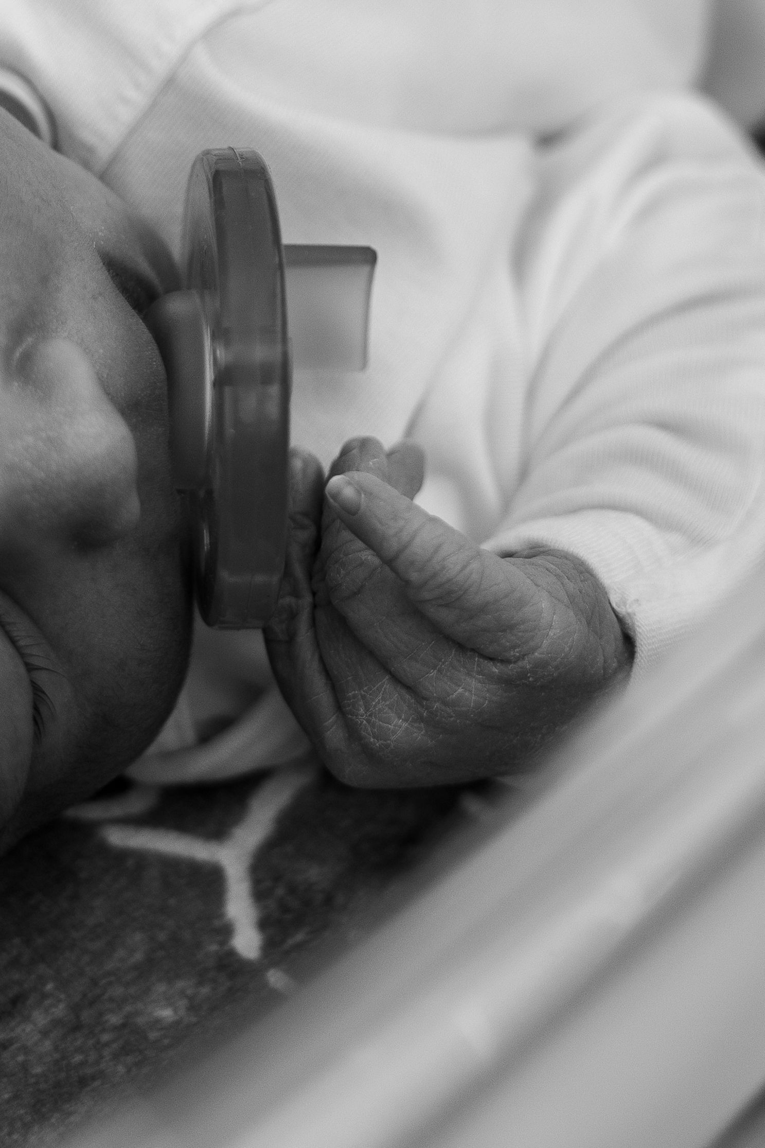 Newborn detail of baby's fingers while using a pacifier.