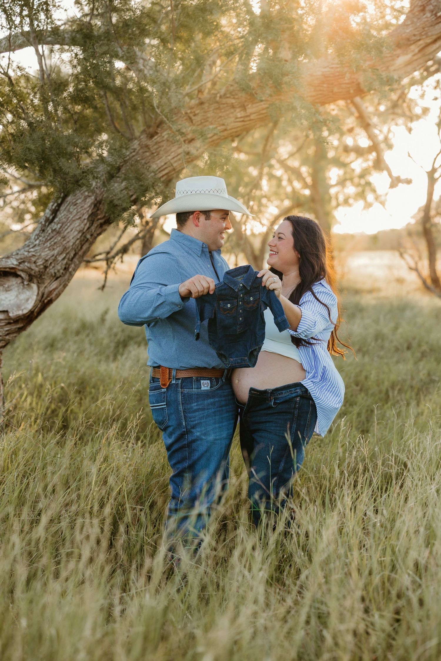 A playful maternity photoshoot in a rustic outdoor setting during golden hour.