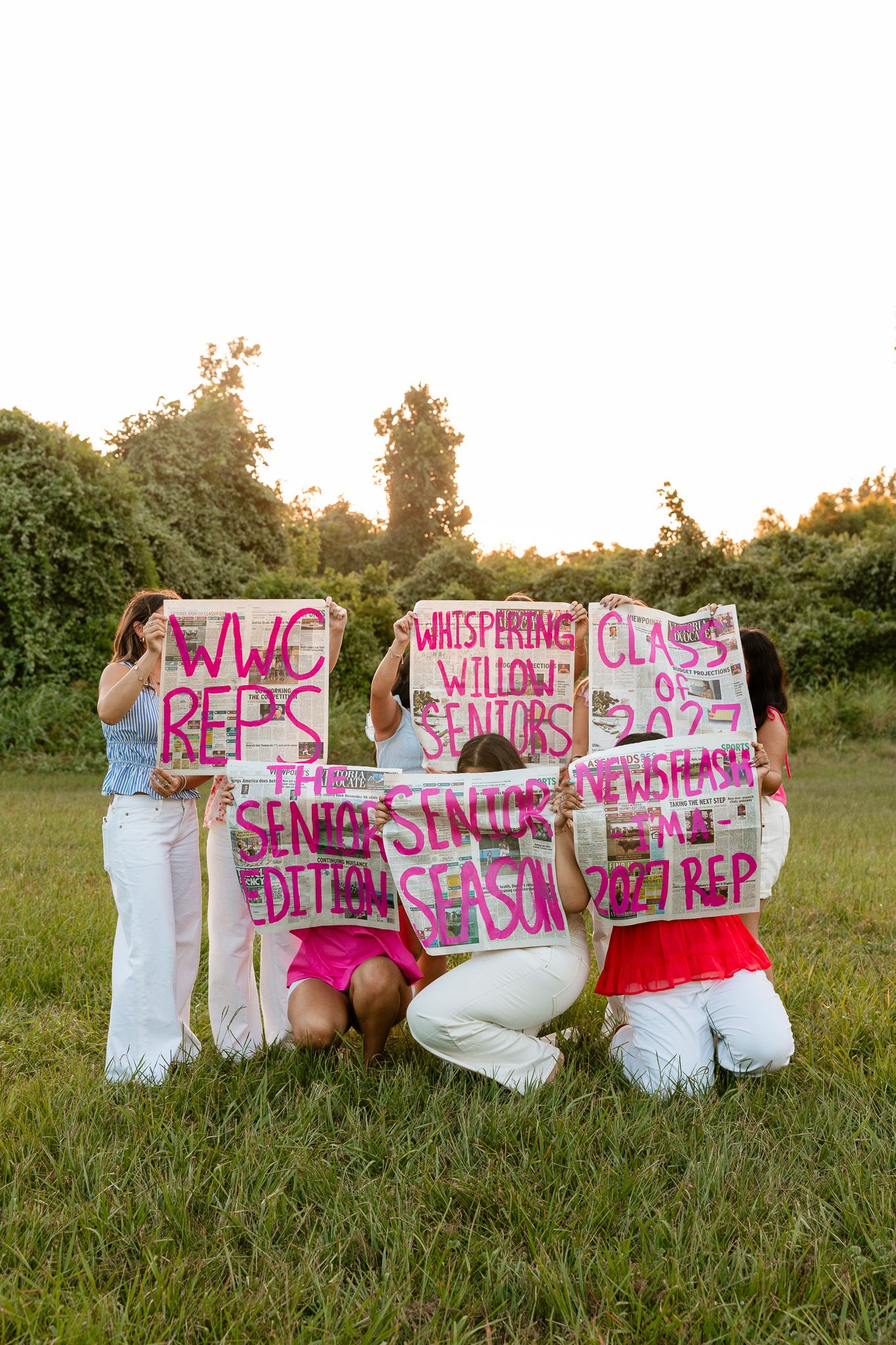 Group of high school seniors holding colorful handmade signs celebrating WWC Reps Senior Edition and Class of 2027 outdoors.
