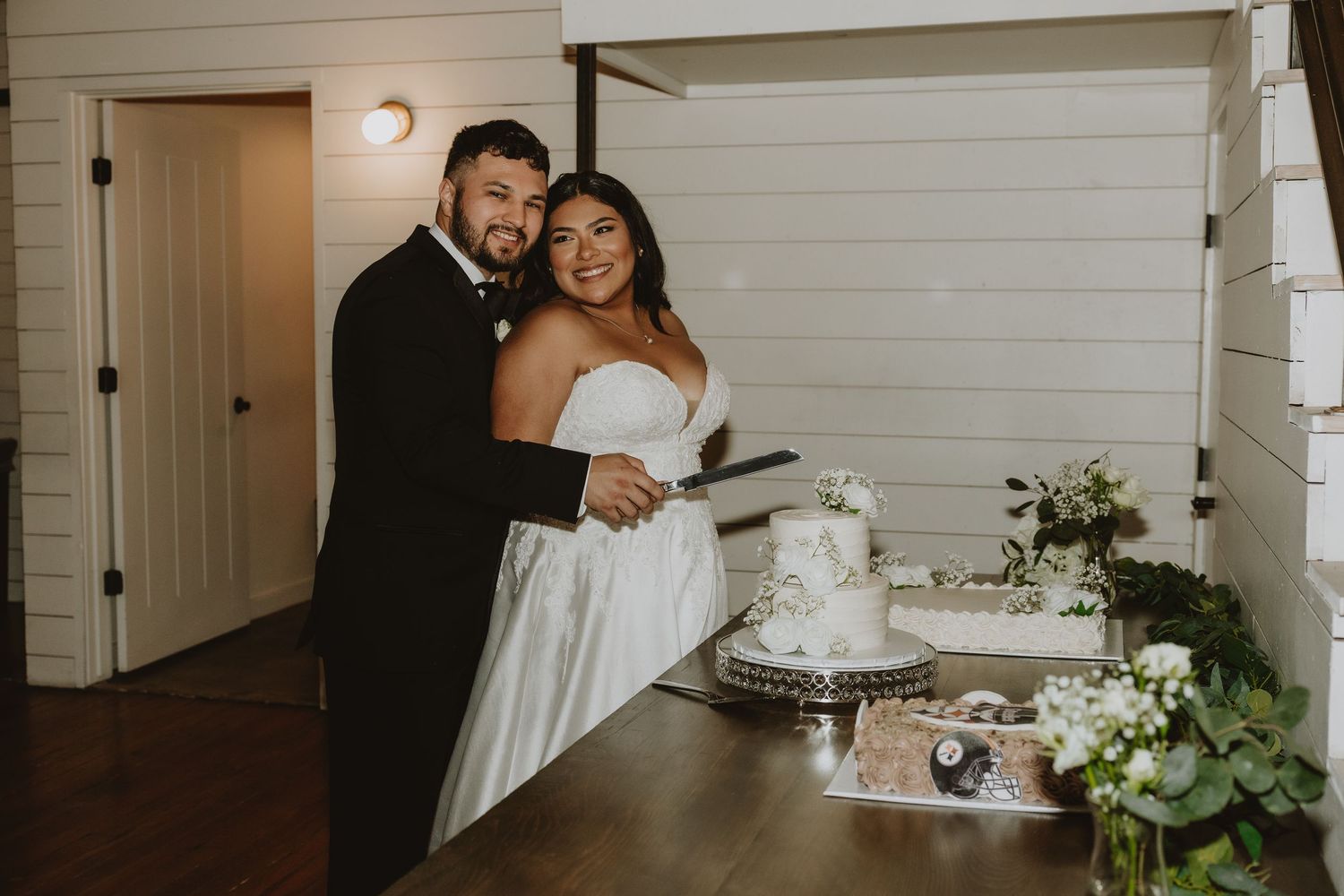 Newlyweds share a playful moment near their wedding cake.