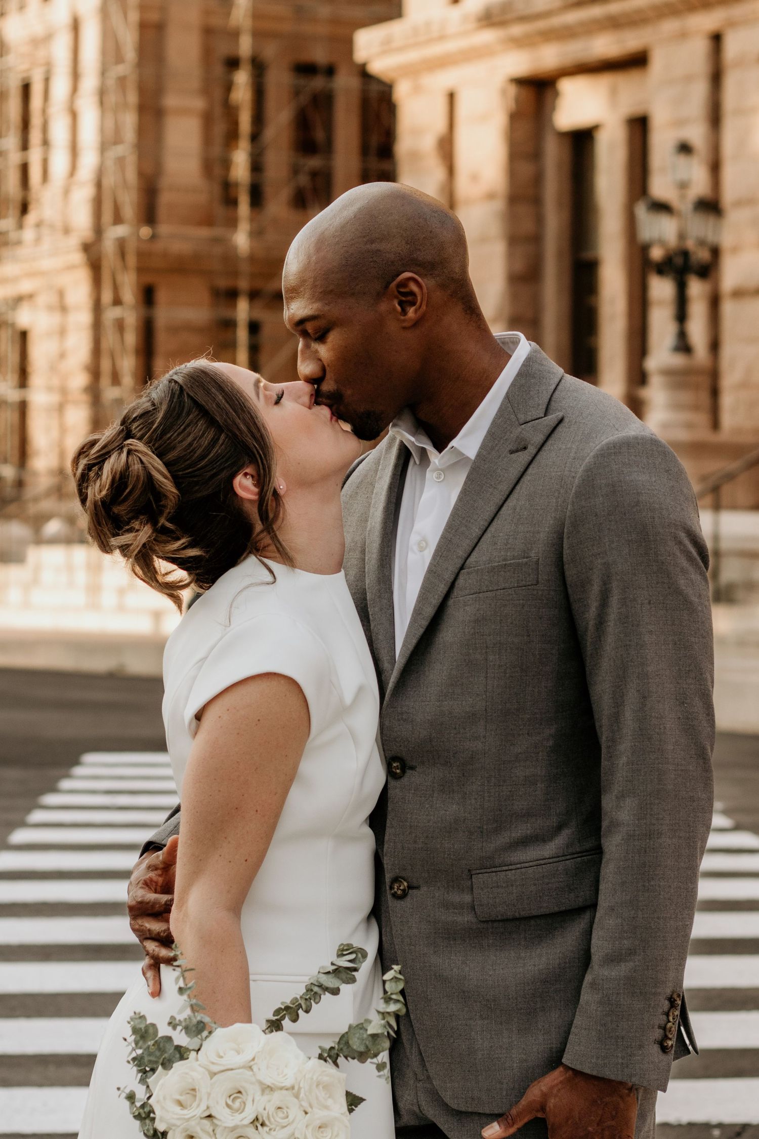 Couple in formal attire sharing intimate moment outdoors.