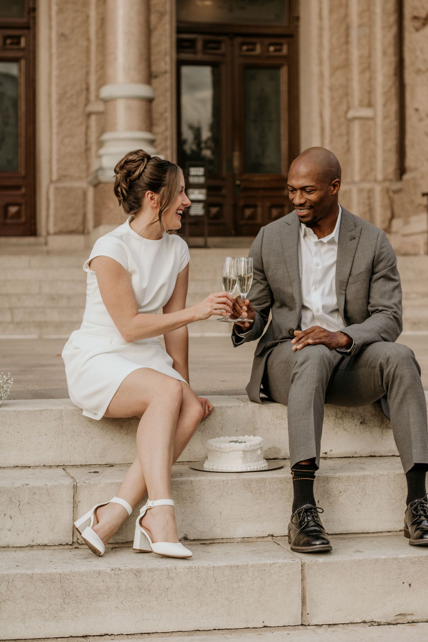 Couple sitting on the steps of Austin Capitol celebrating an engagement.