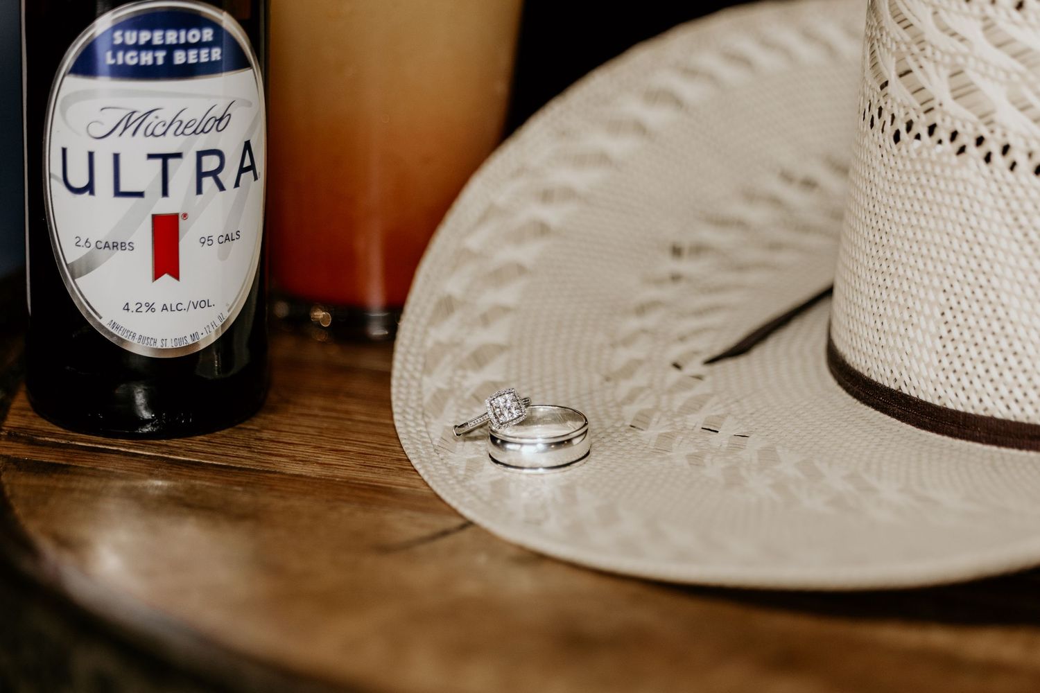 Detail shots of drinks and a cowboy hat on a textured surface in warm lighting.