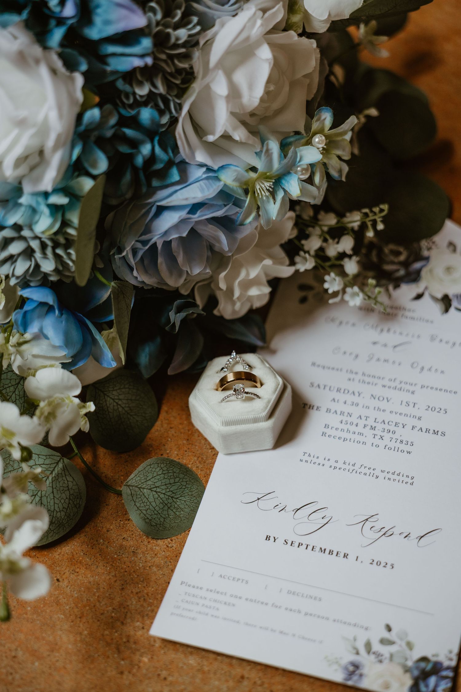 Wedding invitations with blue and white floral arrangements and elegant calligraphy.