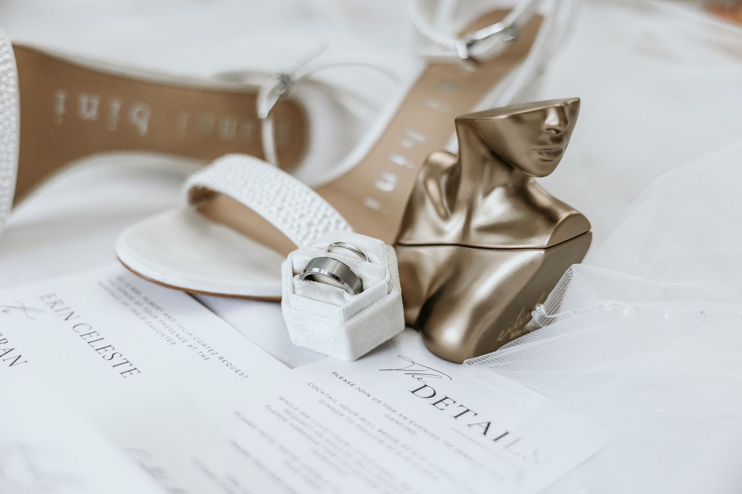 Wedding invitation and accessories arranged on white background.