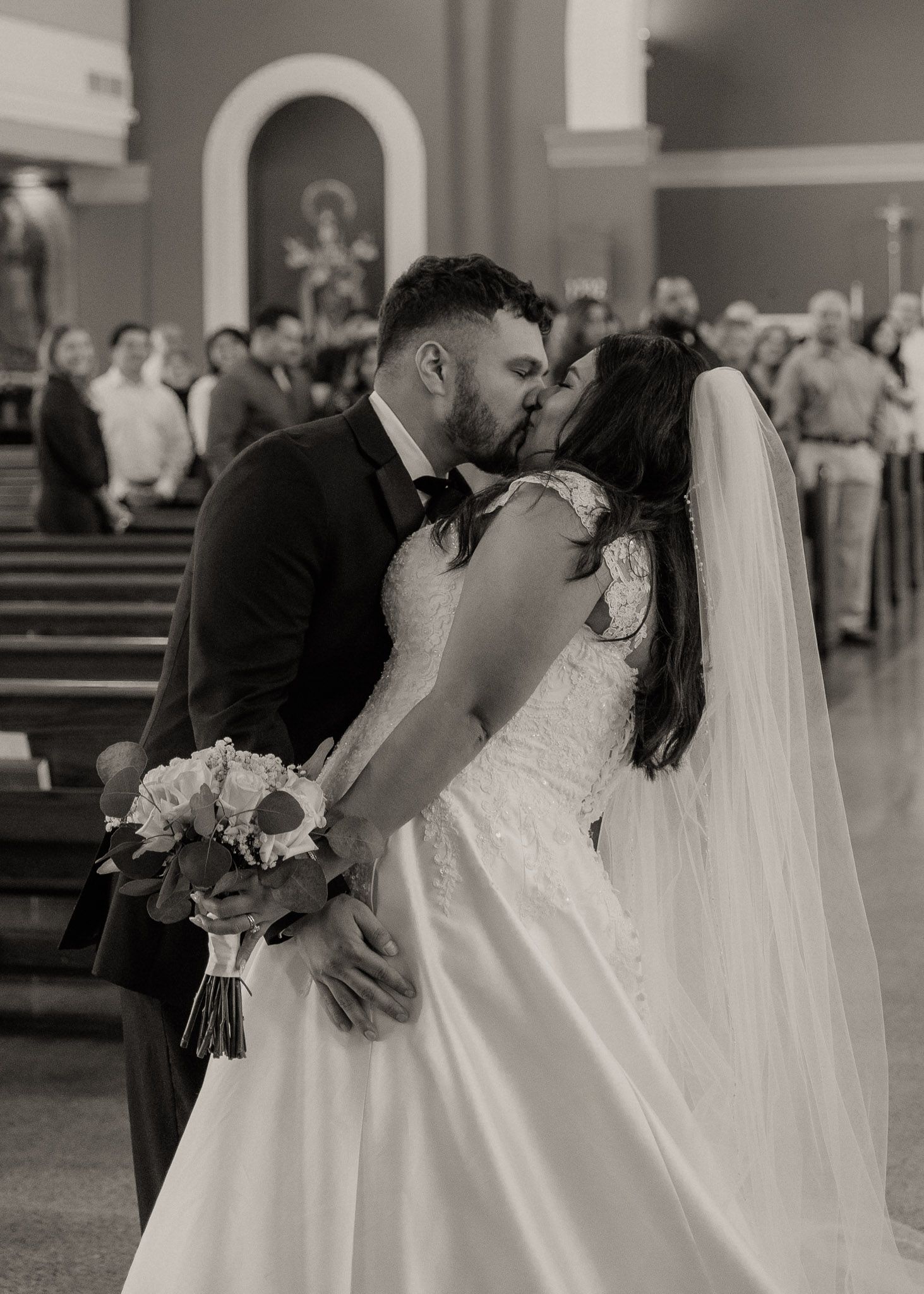 A series of black and white wedding photos showing a couple sharing romantic moments in a church setting.