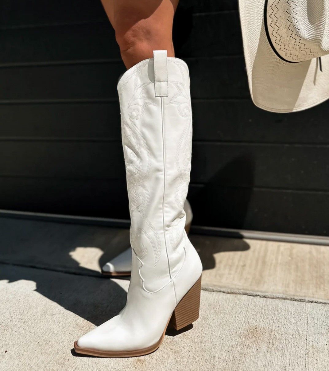 A series of close-up shots showing white leather cowboy boots with stitched details and wooden heels on a light carpet.
