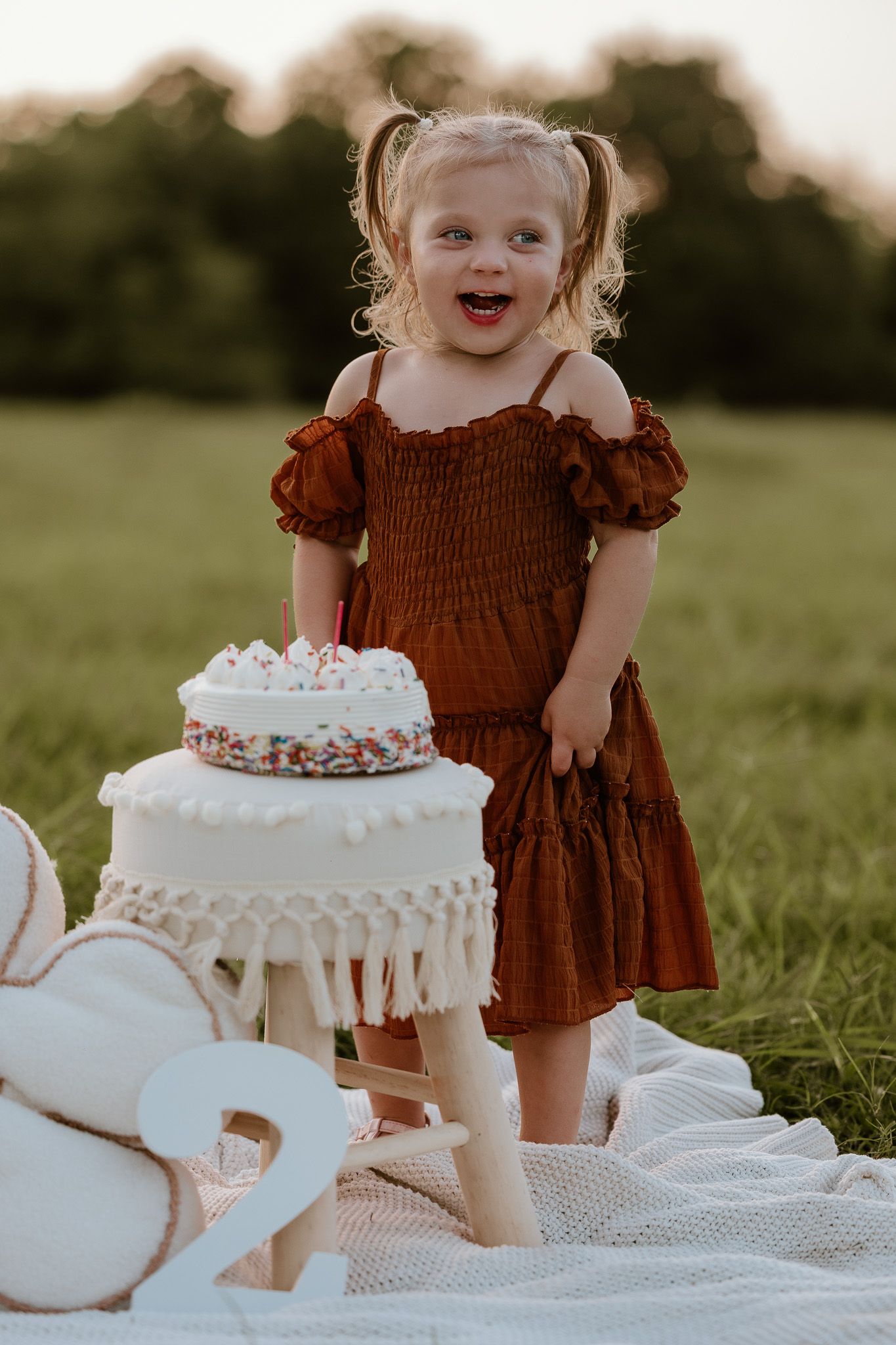 A playful moment captured during a cake smash photo session outdoors.