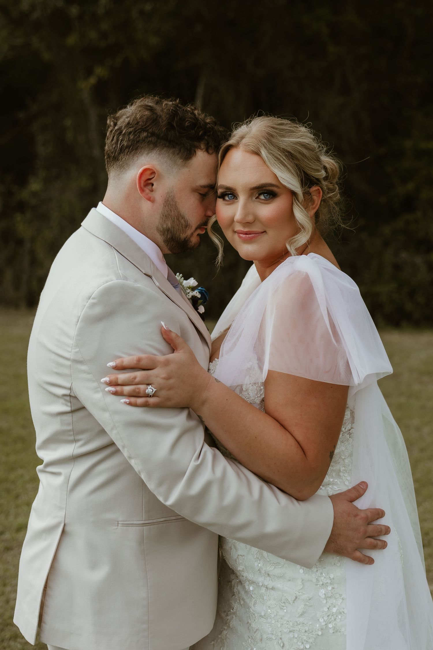 Romantic wedding portrait in soft natural lighting with white attire.