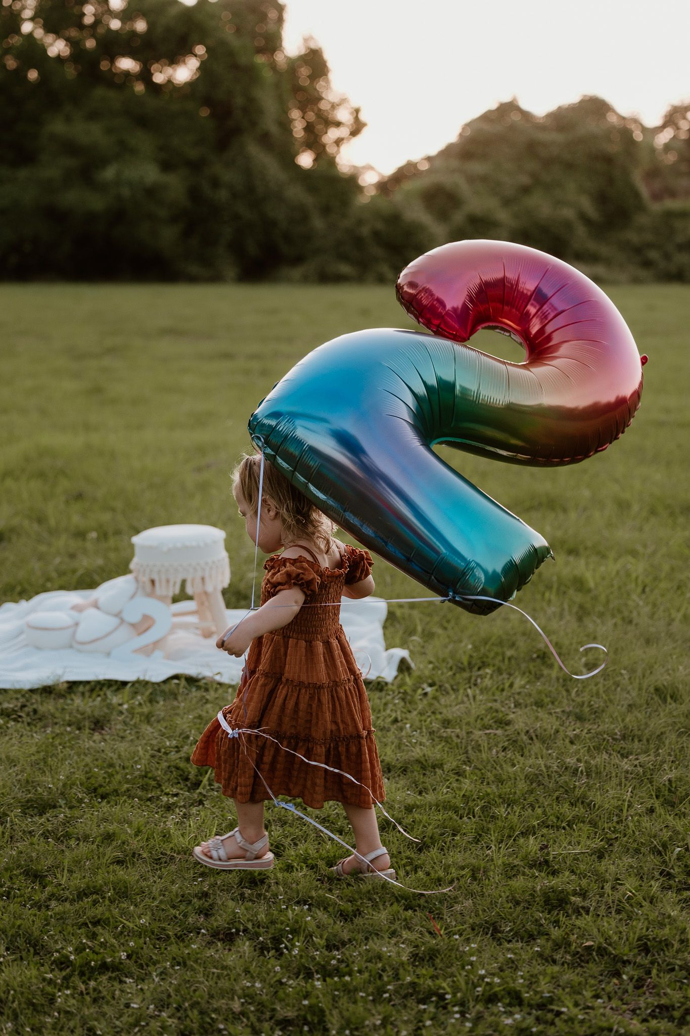 A colorful iridescent number 2 balloon during a 2nd birthday session.