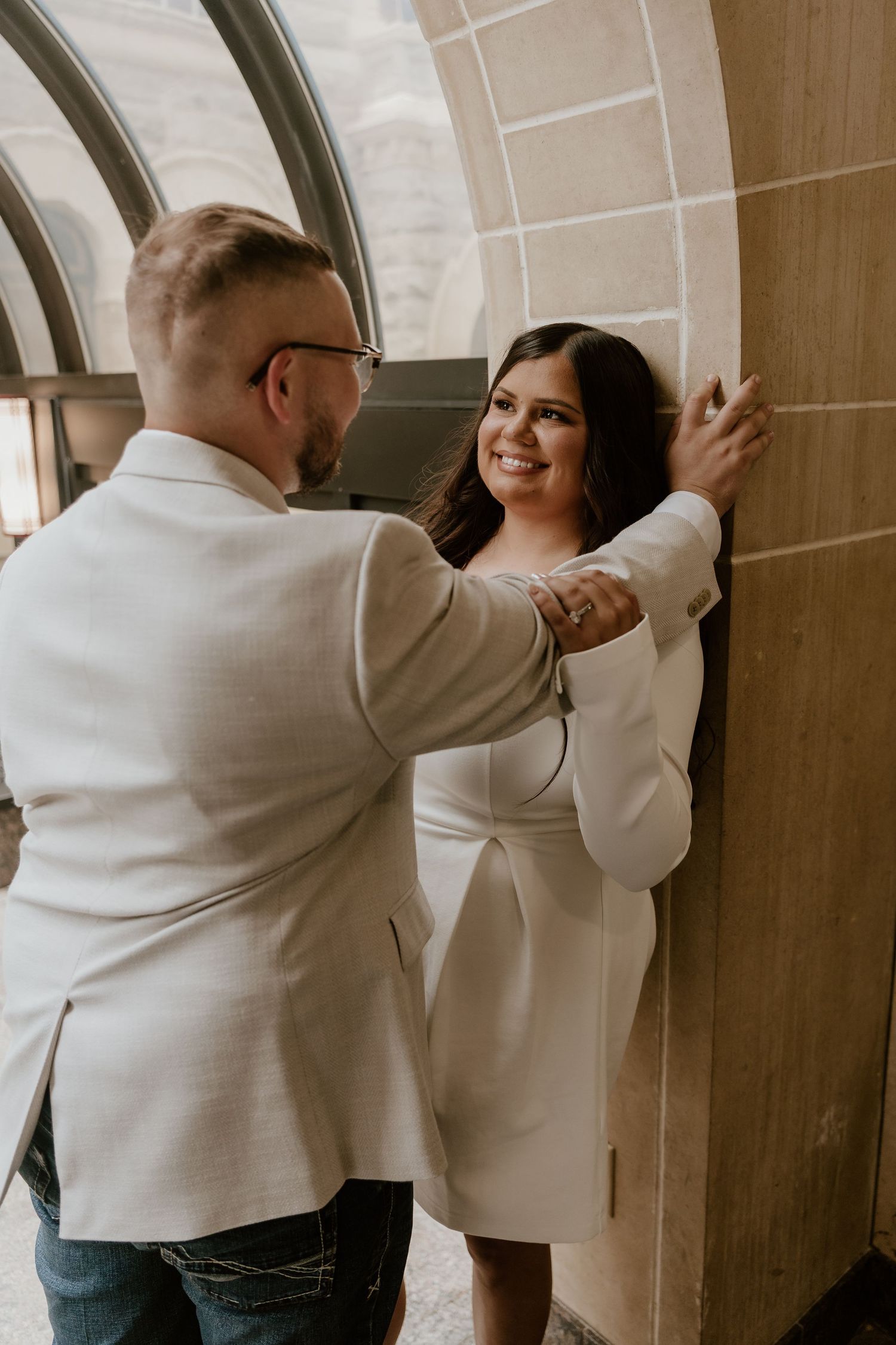 Couple in matching white outfits dancing together in an elegant indoor setting.