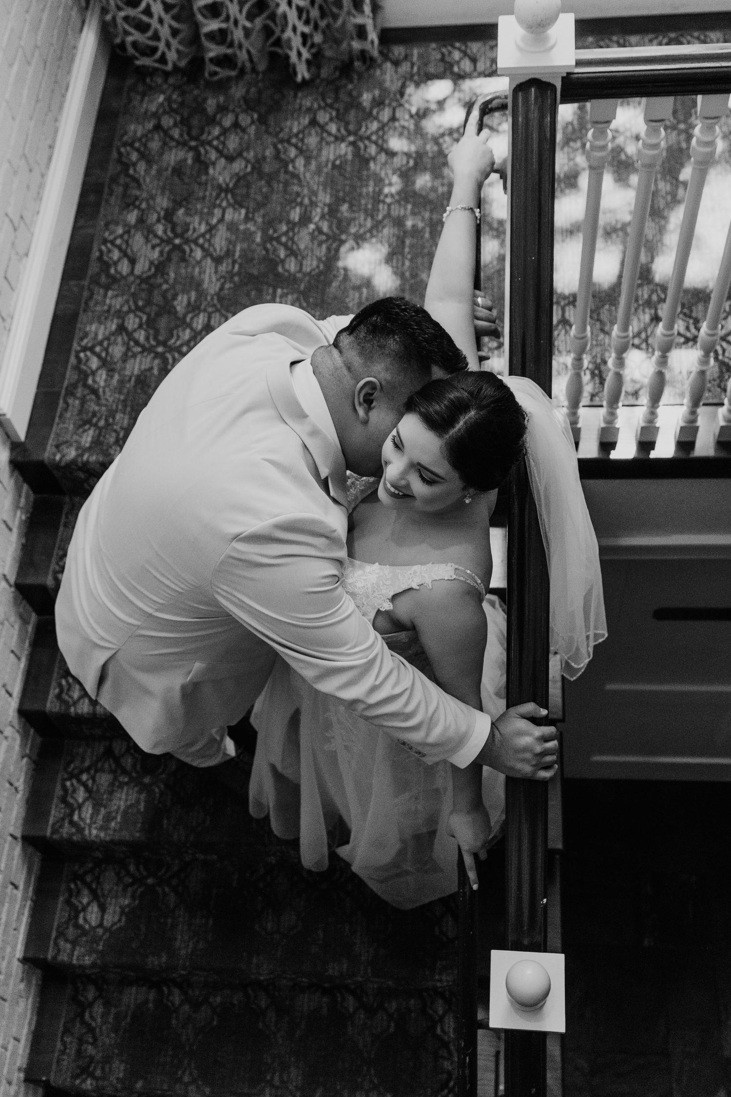 Black and white photo of a romantic dance moment in formal wedding attire.