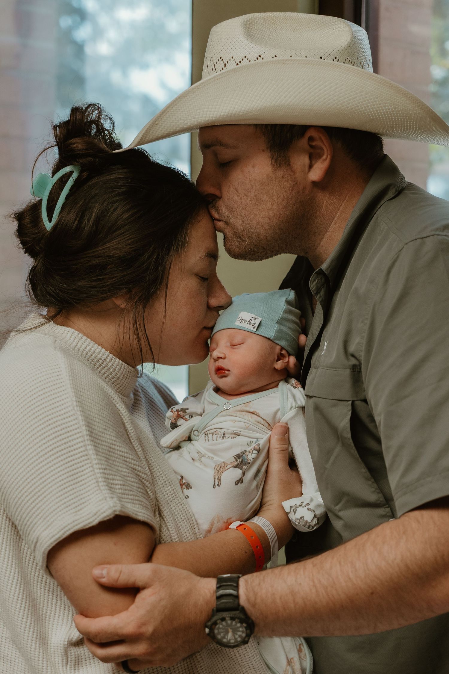 Family sharing intimate moment with newborn baby in Cuero Regional hospital room in Cuero, TX.