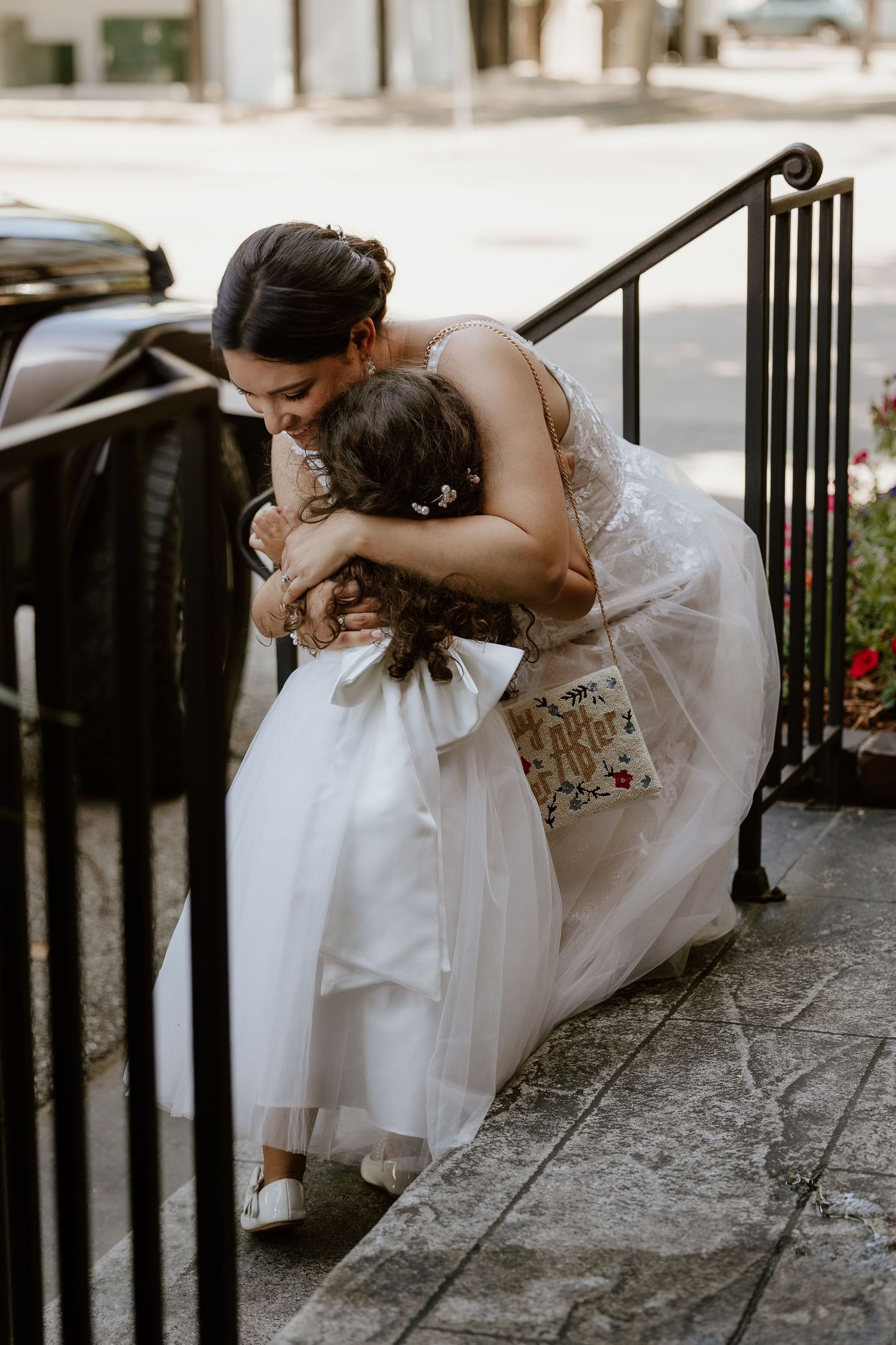 A sweet moment captured on outdoor steps with flowing white dresses.