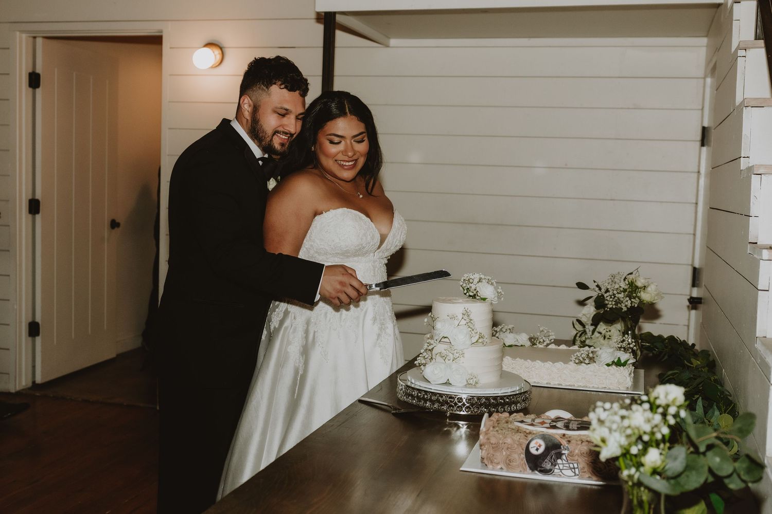 Couple laughs together during their wedding cake cutting ceremony.
