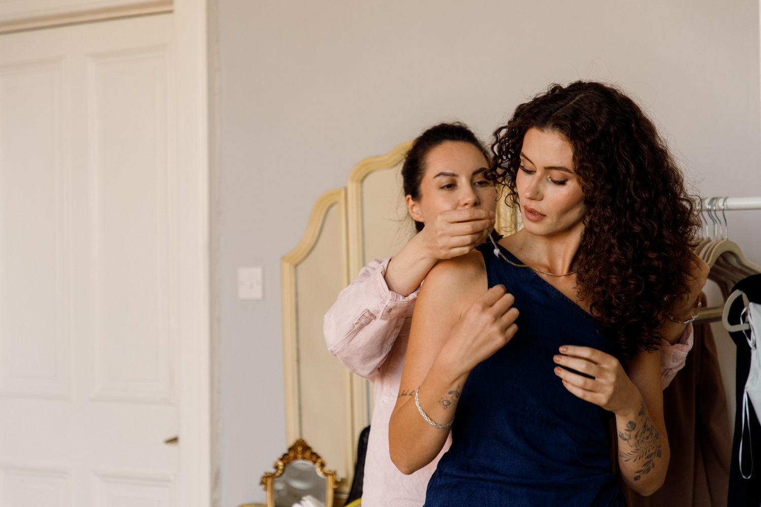 Two people sharing a warm embrace while dancing together in a sunlit room with white walls and a mirror.
