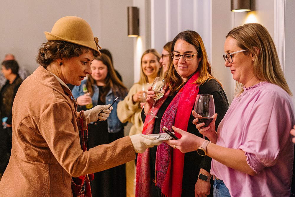 Group of friends enjoying drinks and socializing at a lively indoor gathering.
