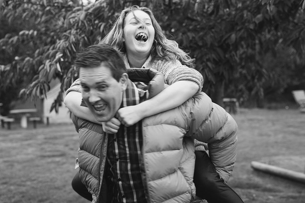 Candid black and white portrait of joyful laughter and embraces in a natural setting.