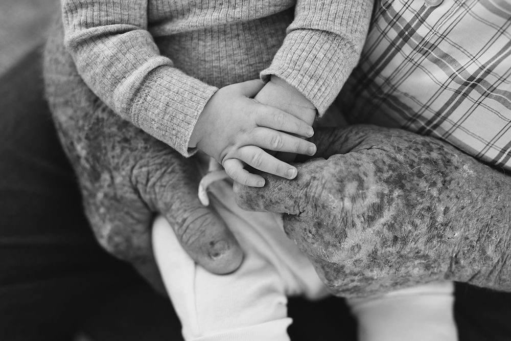 Gentle hands holding each other in black and white photography.