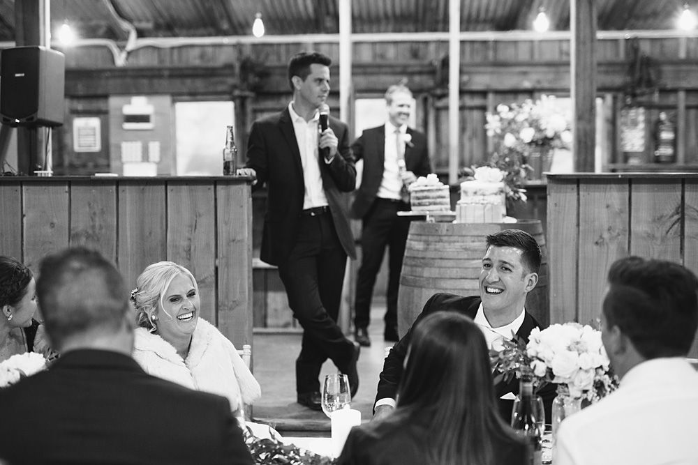 Wedding reception celebration in a rustic venue with guests dining.