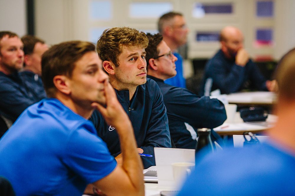 Attentive students in blue uniforms participating in classroom discussion.