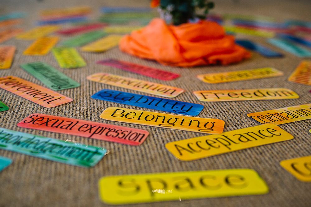 Colorful word cards and labels scattered on textured fabric surface.