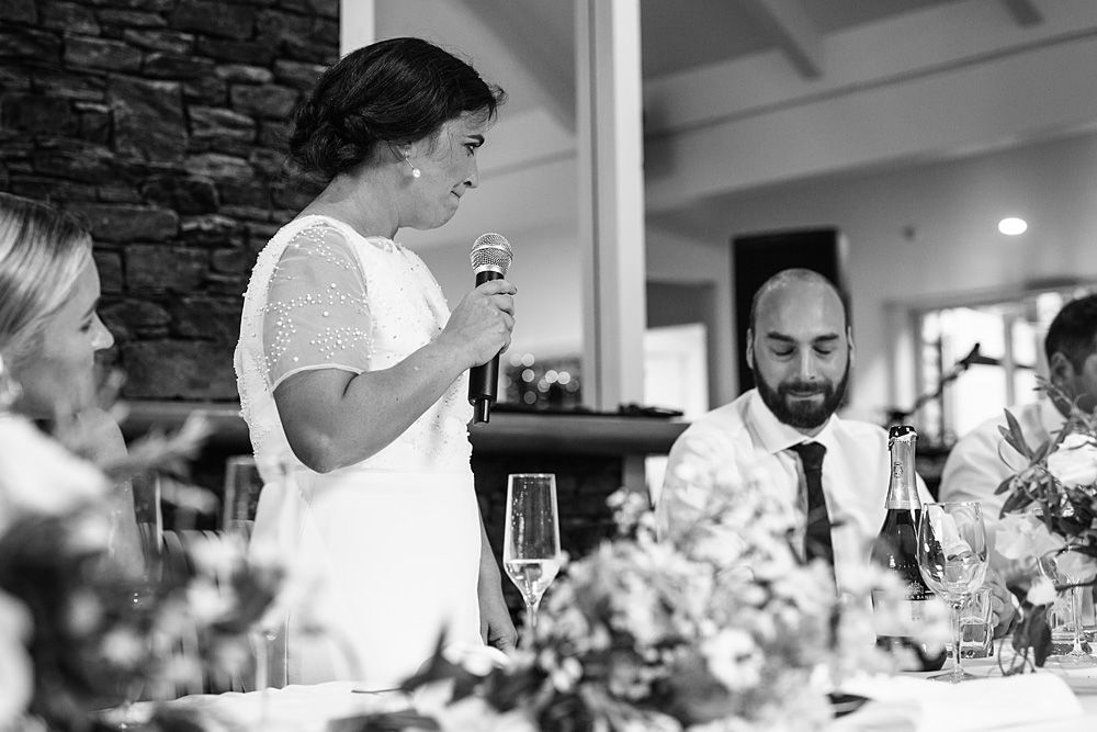 Black and white wedding reception scene with guests dining at decorated tables.