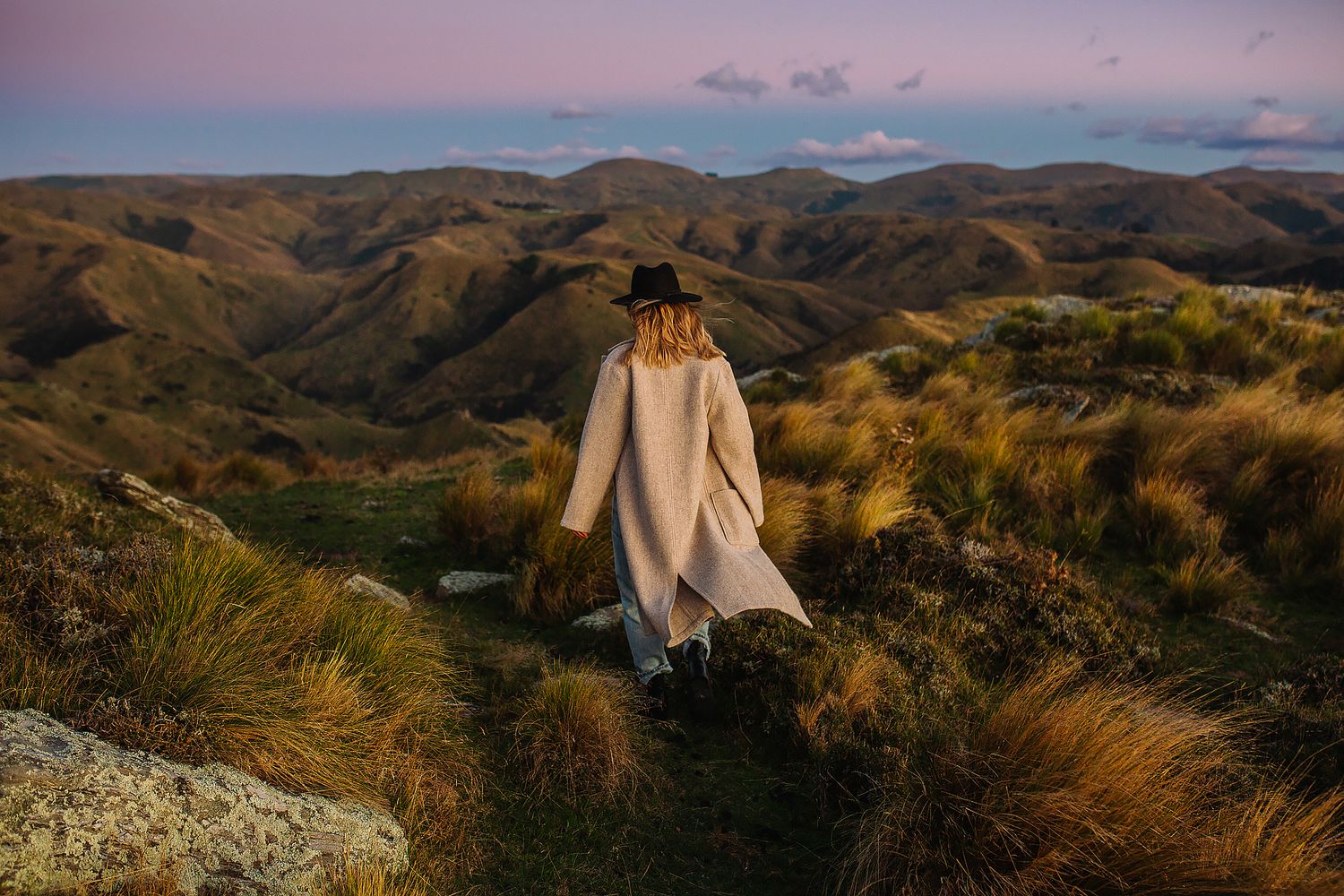 Scenic mountain landscape at sunset with golden grass in foreground.