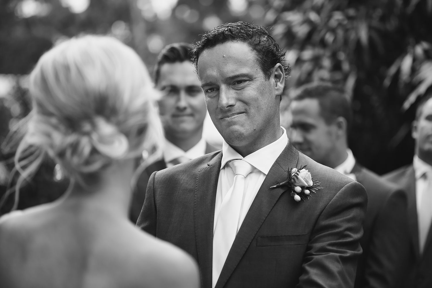 Formal outdoor wedding ceremony with guests gathered in elegant attire.