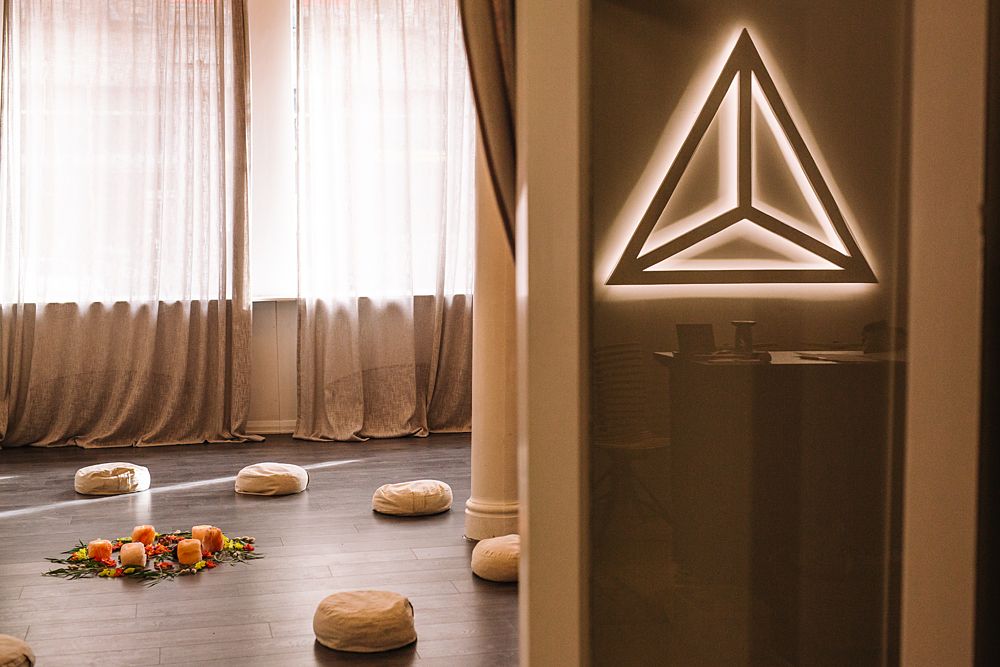 Interior room with geometric lighting fixtures and sheer curtains.