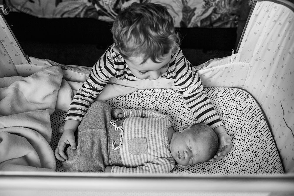 Peaceful image of a baby in striped clothing resting on patterned fabric.