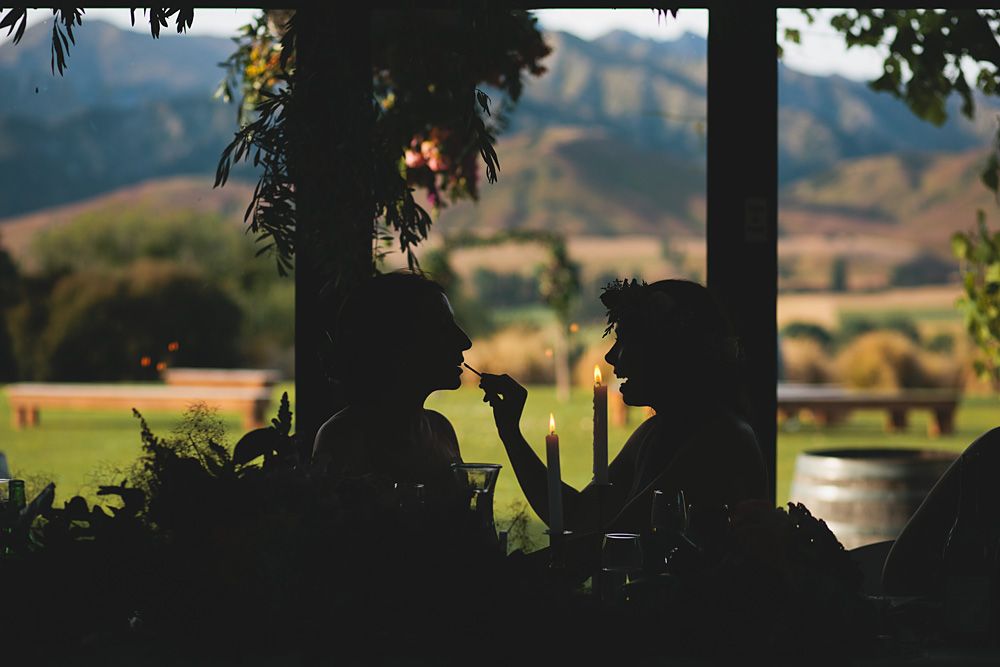 Silhouette of wedding decor against a mountain landscape at sunset.