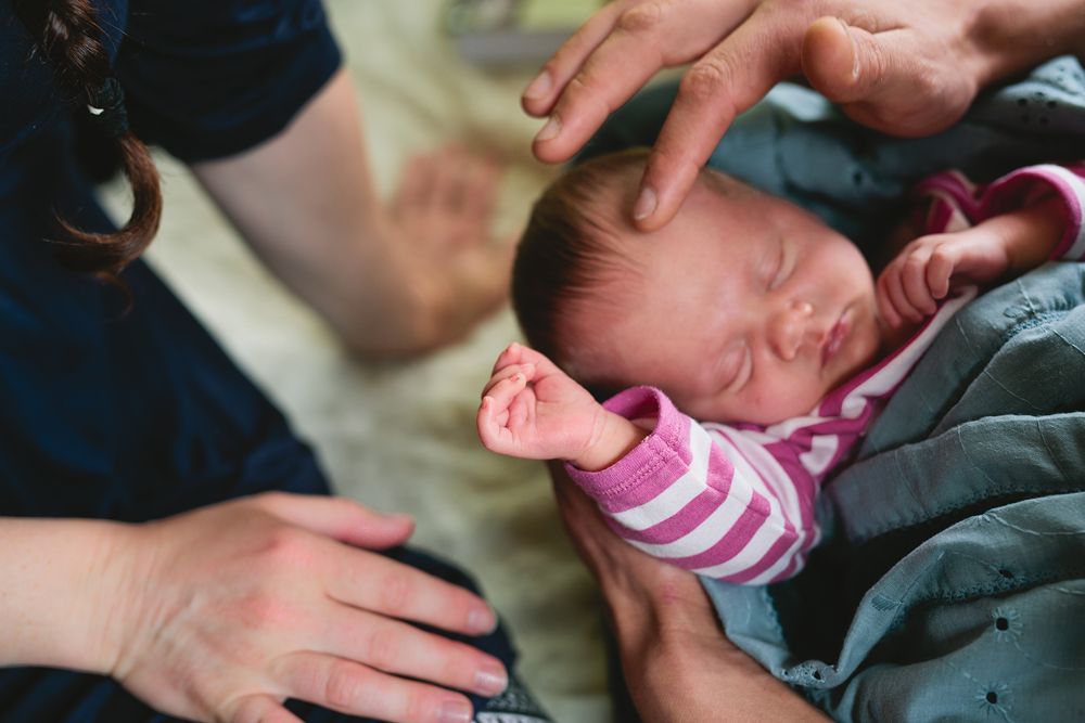 Intimate black and white photo of a baby being held with loving care.