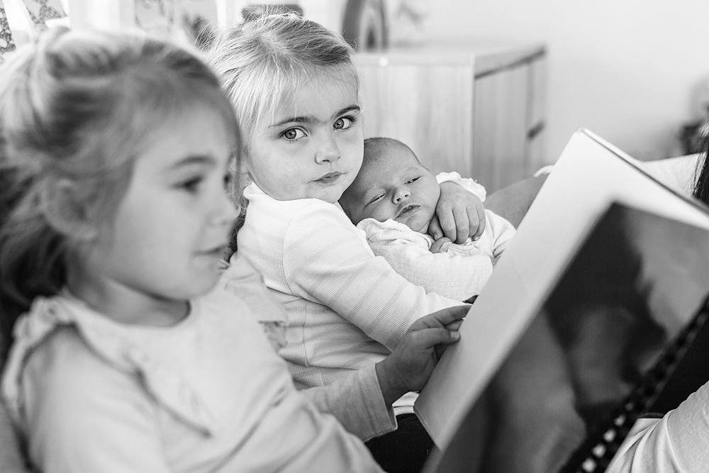Black and white lifestyle photos capturing tender family moments indoors.