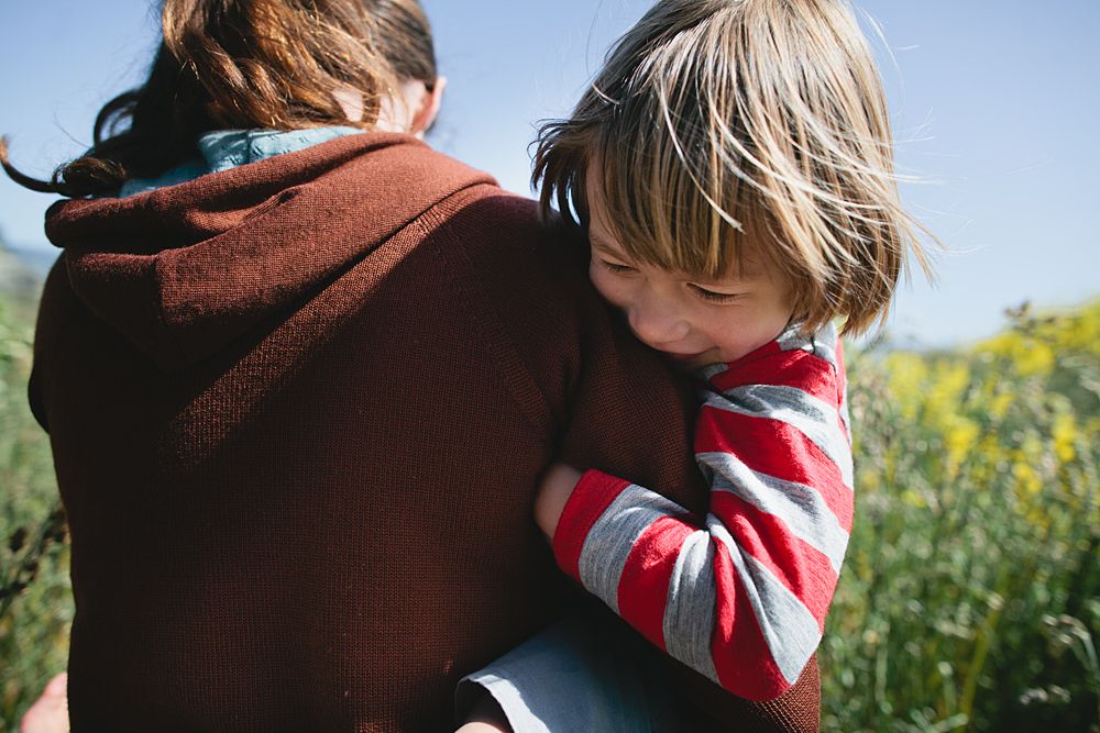 A tender moment of reading together on a sunny day outdoors.