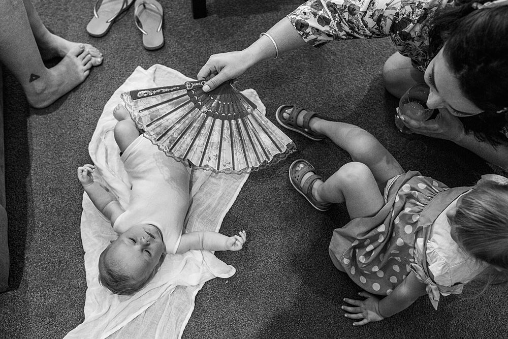 Wedding dress train spread out on floor with hands arranging the fabric.