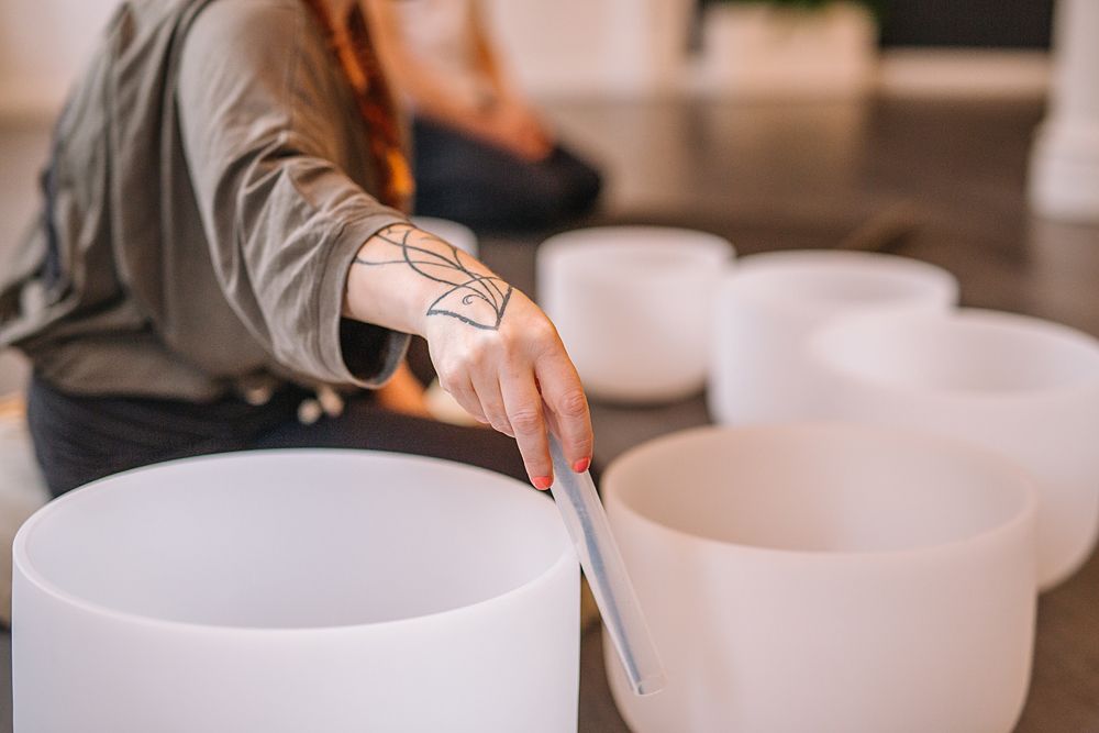 Hands preparing white ceramic bowls on a table.