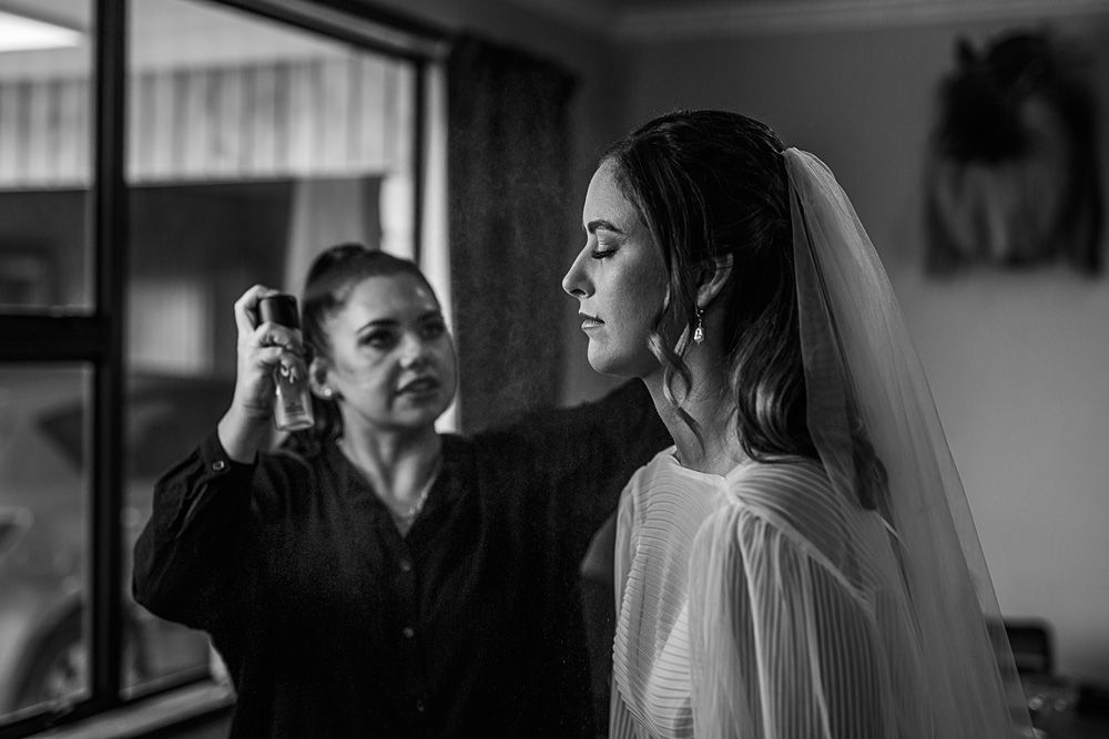 A black and white image of wedding preparation with styling in progress.