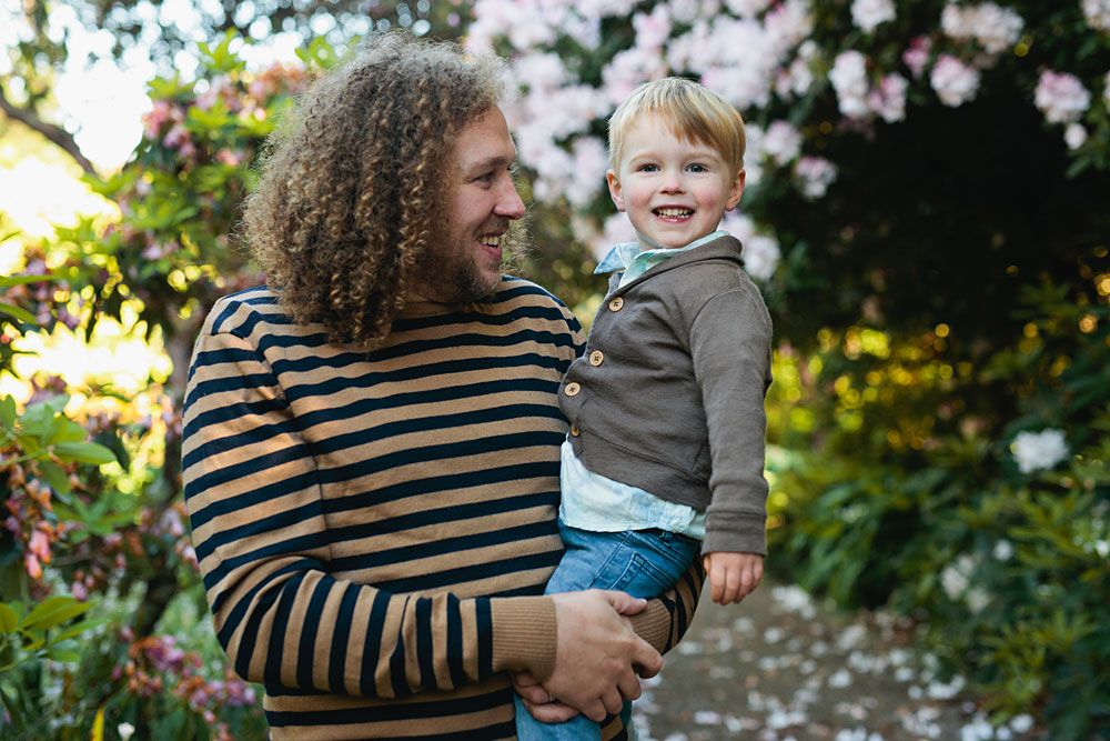 Family enjoying springtime moments among blooming white flowers in a garden.